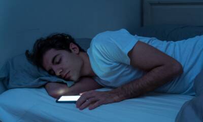 uomo a letto con smartphone