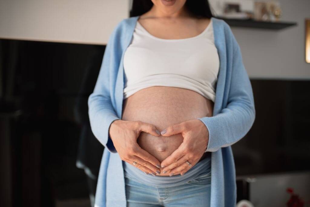 donna incinta gravidanza mani cuore