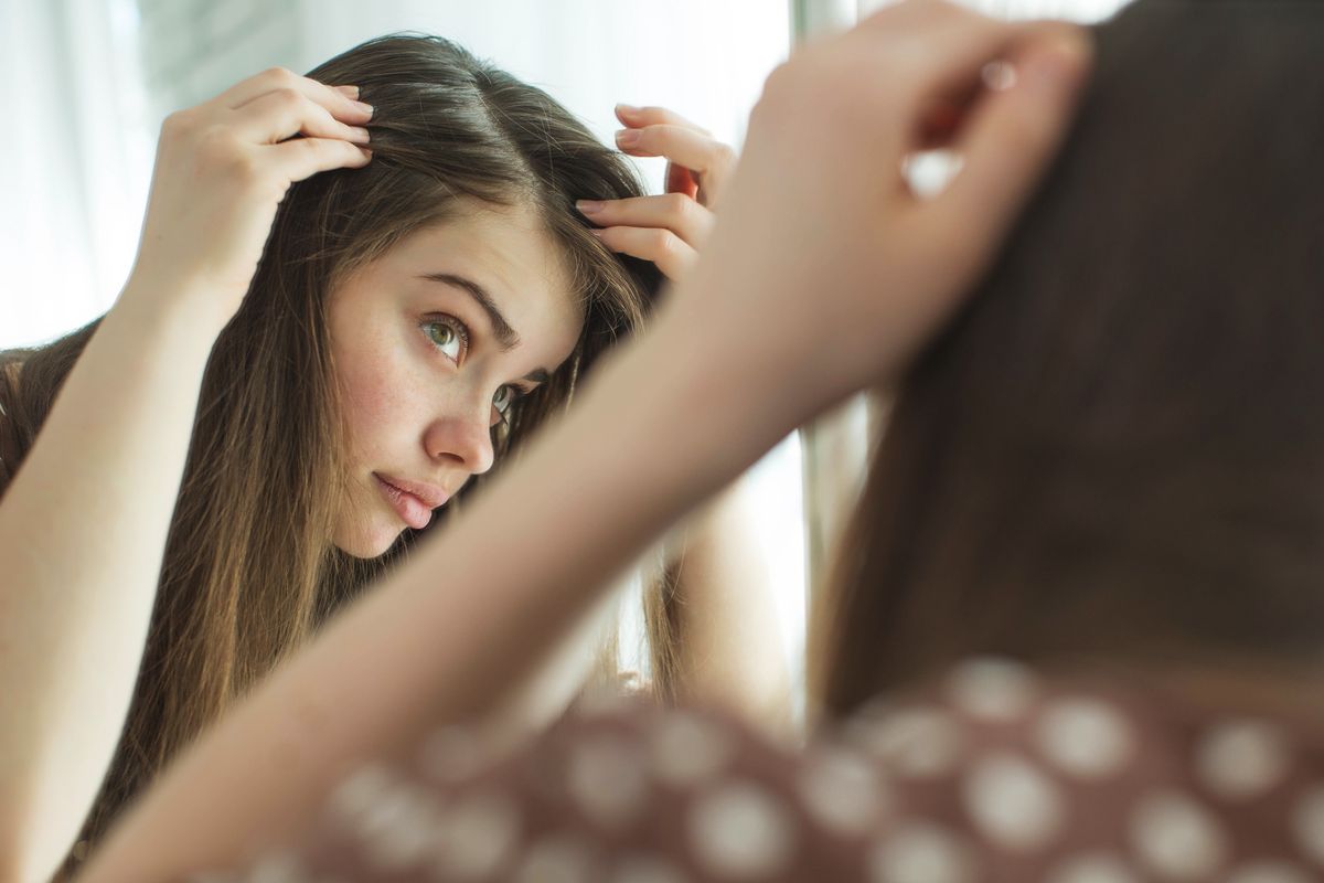 girl checking hair mirror